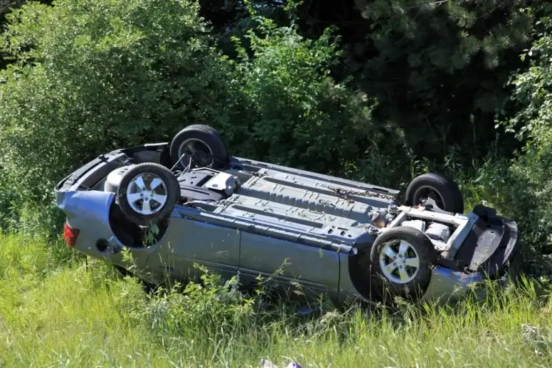 A car rollover accident on the grass.