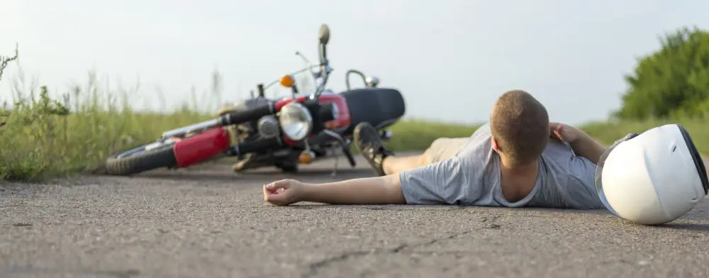 A motorcyclist experiencing a road rash injury.